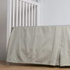 Bria Crib Skirt | Eucalyptus | cotton sateen cribi skirt with a center pleat shown straight on from a slight angle in a crib without a crib mattress.