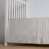 Bria Crib Skirt | Mineral | cotton sateen cribi skirt with a center pleat shown straight on from a slight angle in a crib without a crib mattress.