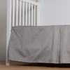 Bria Crib Skirt | Moonlight | cotton sateen cribi skirt with a center pleat shown straight on from a slight angle in a crib without a crib mattress.