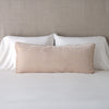 Carmen Throw Pillow | Pearl | Silk velvet lumbar pillow with petite ruffle, leaning upright against neutral bedding and headboard.
