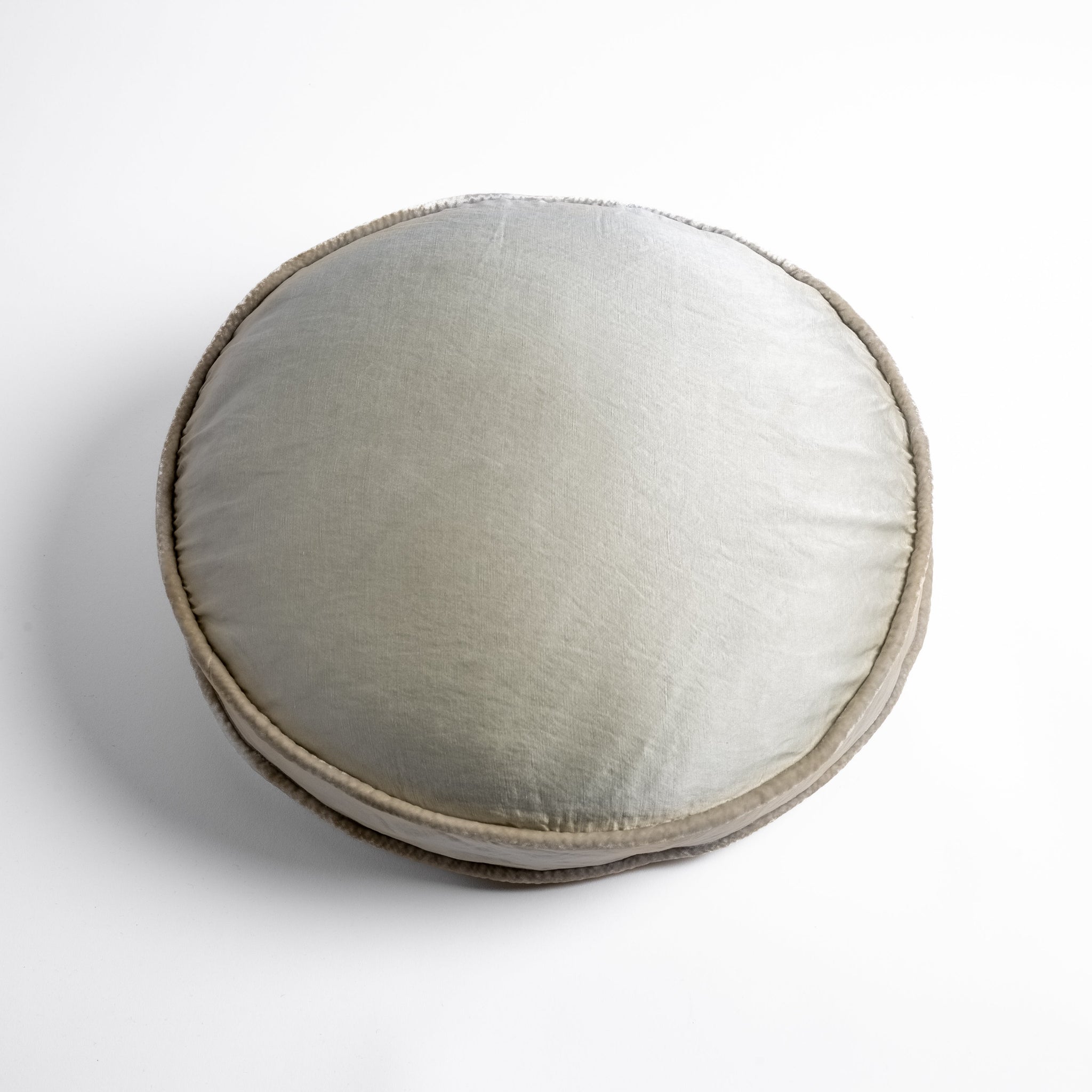 Paloma Throw Pillow | Parchment | 18" round charmeuse pillow with silk velvet trim at gusset shot from overhead on a white background