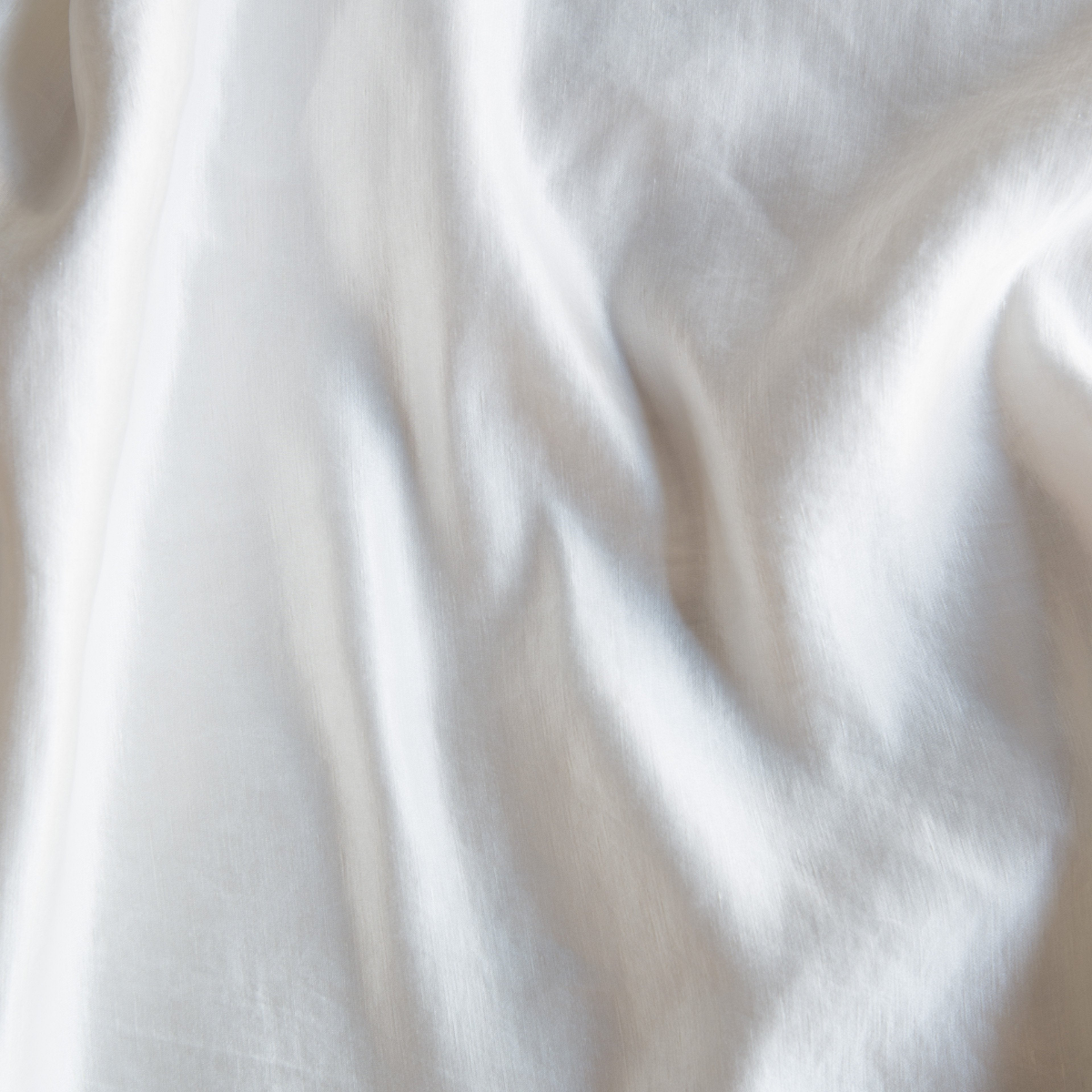 Paloma Blanket | Winter White | A close up of charmeuse fabric in winter white, softer and warmer in tone than classic white.