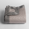 Cirillo Baby Blanket | Fog | a folded quilted cotton sateen baby blanket with its corner folded down to show the trim contrast - shot against a white background.