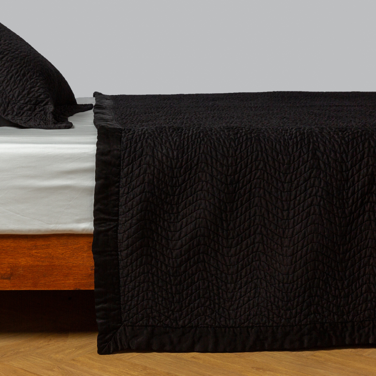 Cirillo Coverlet | Corvino | quilted cotton sateen coverlet with matching sham on a winter white fitted sheet - side view.