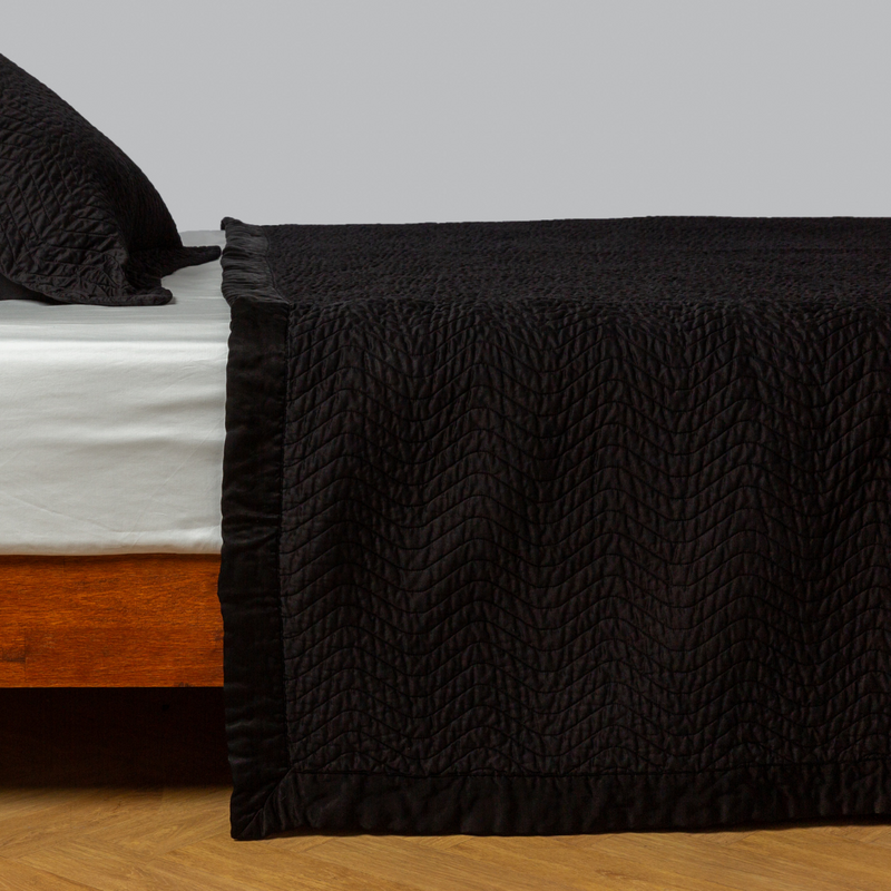 Cirillo Coverlet | Corvino | quilted cotton sateen coverlet with matching sham on a winter white fitted sheet - side view.