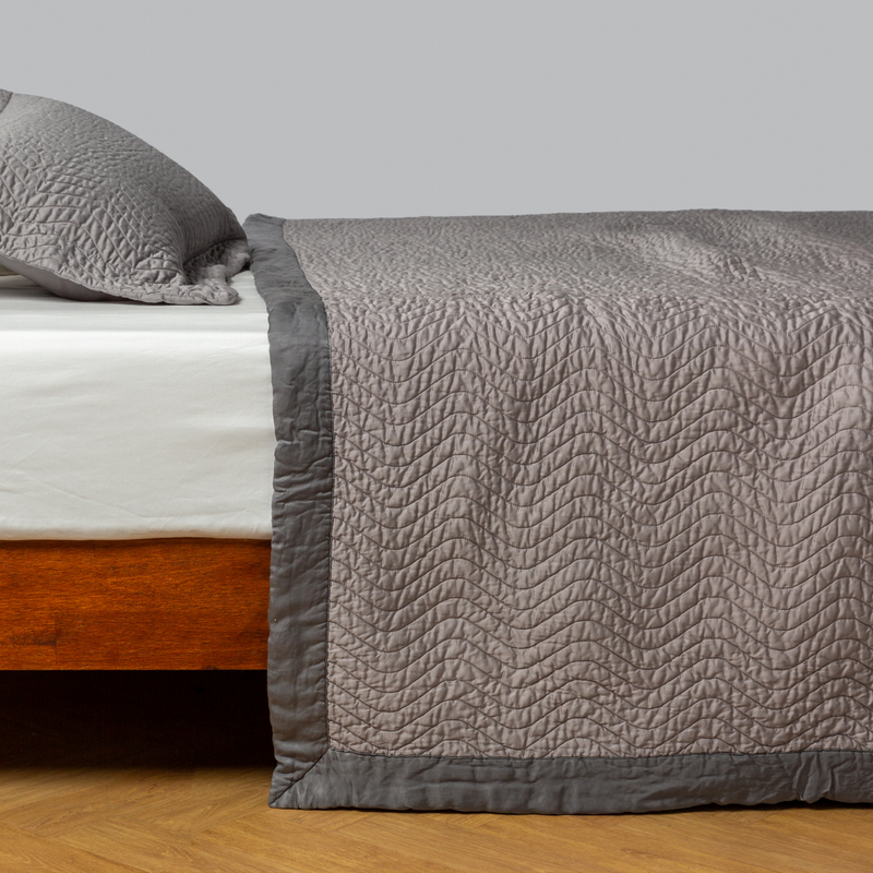 Cirillo Coverlet | Fog | quilted cotton sateen coverlet with matching sham on a winter white fitted sheet - side view.