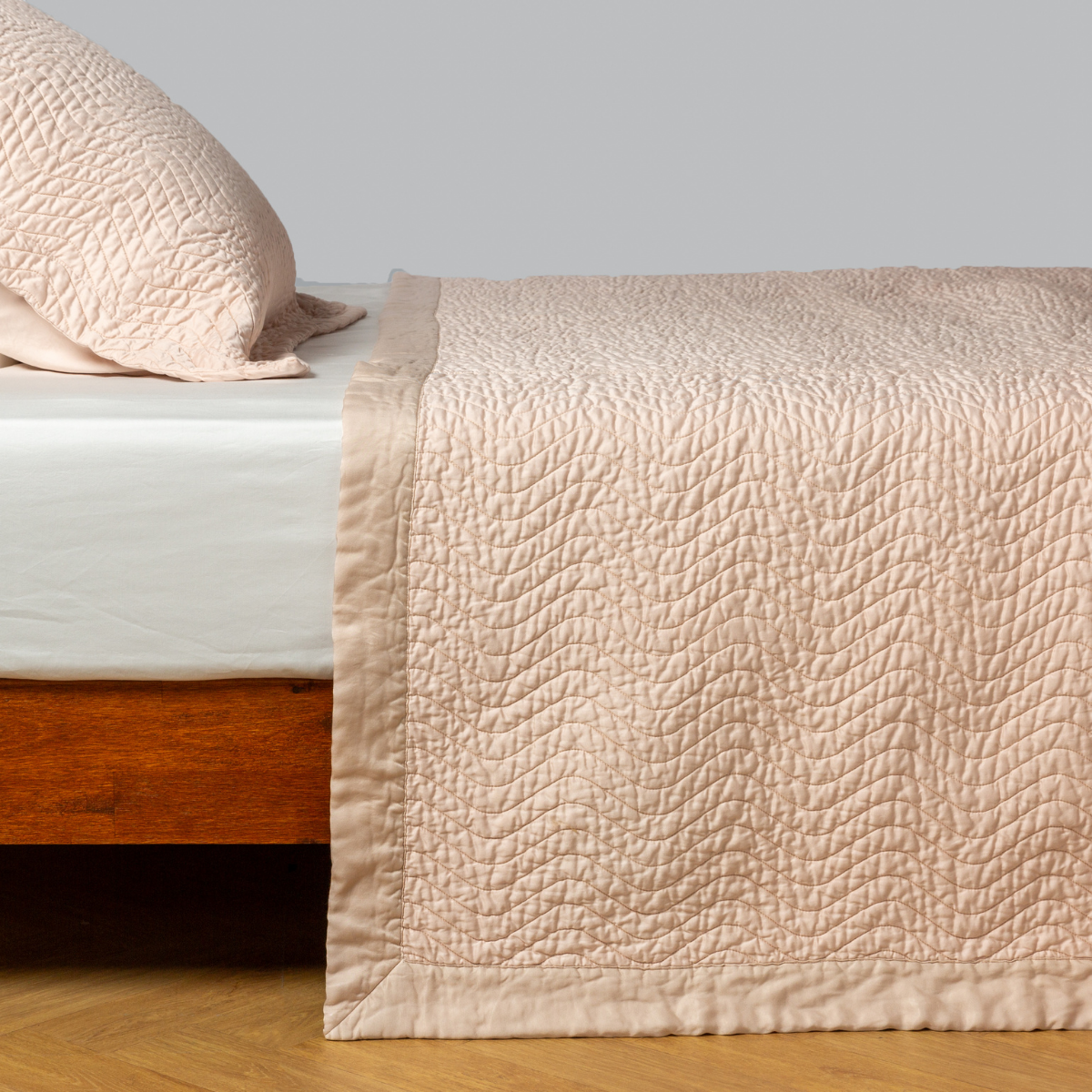 Cirillo Coverlet | Pearl | quilted cotton sateen coverlet with matching sham on a winter white fitted sheet - side view.