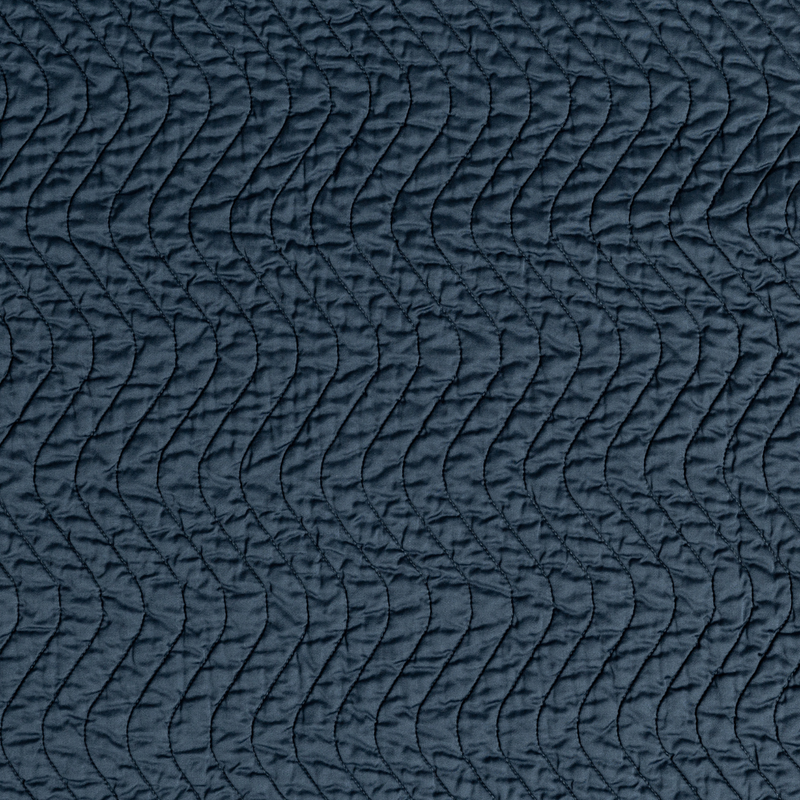 Cirillo Baby Blanket | Midnight | A close up of quilted cotton sateen fabric in midnight, a rich indigo tone.