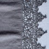 Frida Flat Sheet | Moonlight | A close up of Frida, an antique cotton lace trim on a linen body, shown in moonlight, a saturated, cool, mid-dark grey tone.