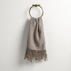 Frida Guest Towel | Fog | Lace trimmed linen guest towel  draped through a decorative towel ring against a plain white background.