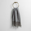 Frida Guest Towel | Moonlight | Lace trimmed linen guest towel  draped through a decorative towel ring against a plain white background.