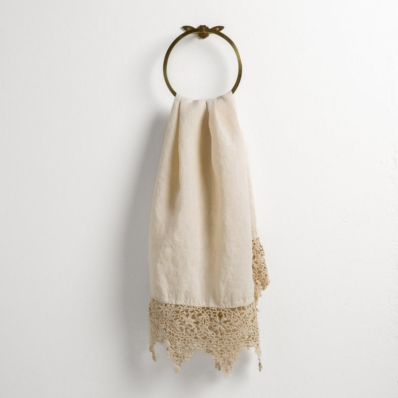 Frida Guest Towel | Parchment | Lace trimmed linen guest towel  draped through a decorative towel ring against a plain white background.