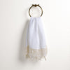 Frida Guest Towel | White | Lace trimmed linen guest towel  draped through a decorative towel ring against a plain white background.