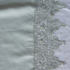 Frida Pillowcase (Single) | Eucalyptus | A close up of Frida, an antique cotton lace trim on a linen body, shown in eucalyptus, a soft light green.