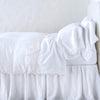 Linen Flat Sheet | White | lace trimmed flat sheet shown with monochromatic  bedding - side view.