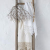 Frida guest towels in white and winter white, draped over a decorative wooden ladder.