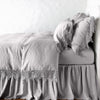 Frida Pillowcase (Single) | Frida pillowcase in fog on a monochromatic linen bed - side view.