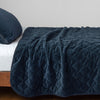 Harlow Twin Coverlet | Midnight | Quilted cotton velvet coverlet draped over a white fitted sheet - side view.