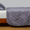 Harlow Coverlet | French Lavender | quilted cotton velvet coverlet draped over a white fitted sheet - side view.