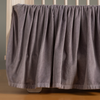 Harlow Crib Skirt | French Lavender | coton velvet crib skirt shown on a light wood crib.