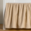 Harlow Crib Skirt | Parchment | cotton velvet crib skirt shown on a white crib .
