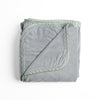 Harlow Blanket | Mineral | overhead angle of the folded blanket with a corner pulled back to show the reverse and trim.