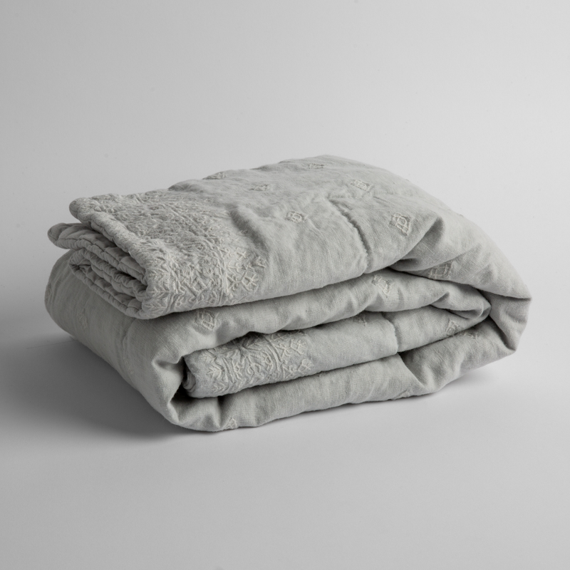 Ines Baby Blanket | Cloud | embroidered linen baby blanket folded and shown  overhead from a slight angle against a white background.