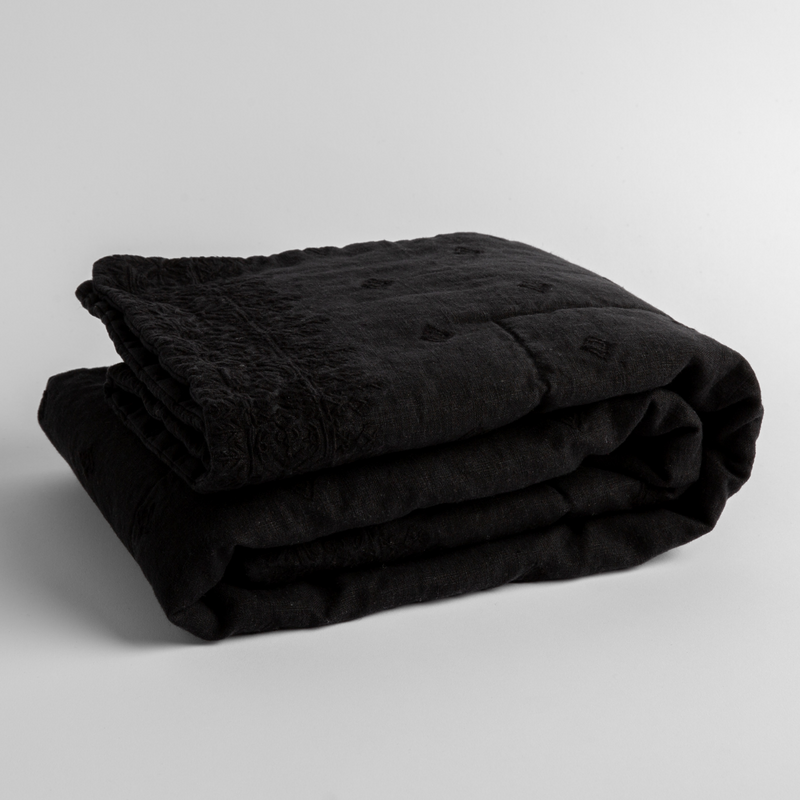 Ines Baby Blanket | Corvino | embroidered linen baby blanket folded and shown  overhead from a slight angle against a white background.