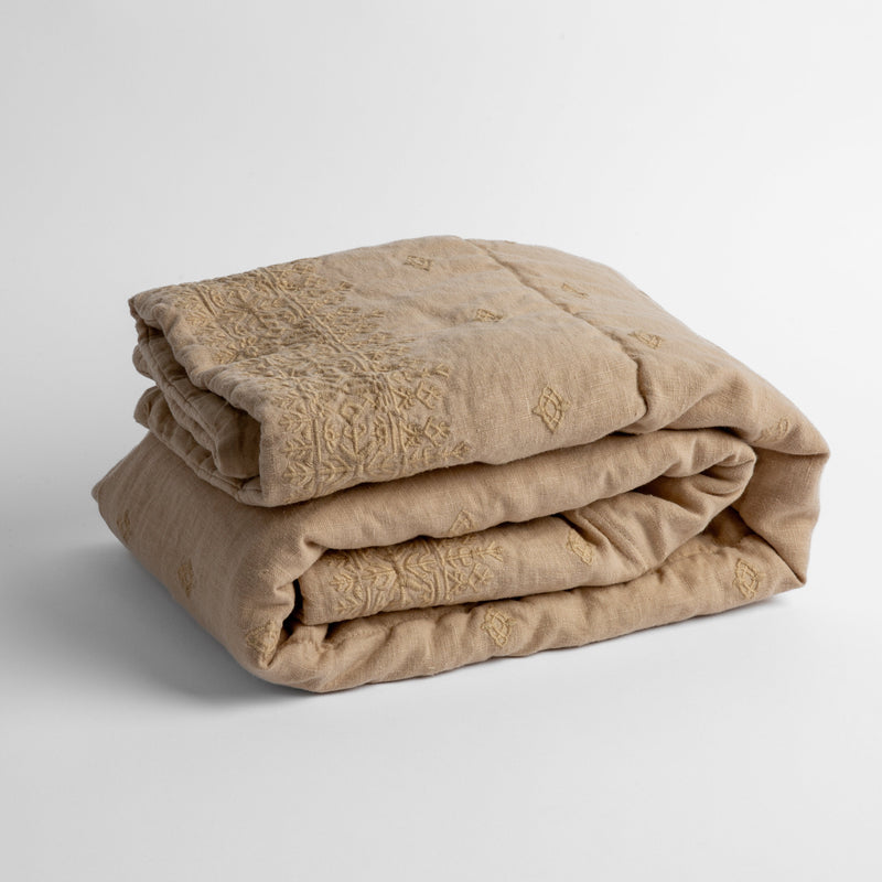 Ines Baby Blanket | Honeycomb | embroidered linen baby blanket folded and shown  overhead from a slight angle against a white background.