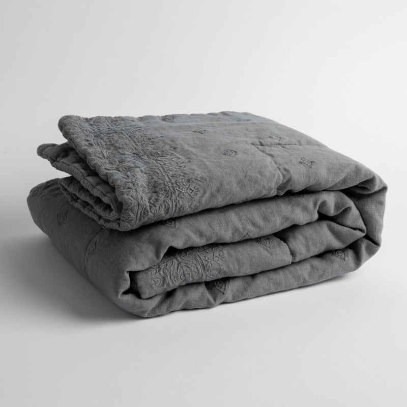 Ines Baby Blanket | Moonlight | embroidered linen baby blanket folded and shown  overhead from a slight angle against a white background.