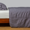 Ines Bedspread | French Lavender | embroidered midweight linen bedspread with matching sham on a bed with a white fitted sheet. shot from the side view, the bedframe is slightly visible against a white background and medium wood floor.