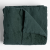 Ines Blanket | Juniper | folded midweight linen blanket with corner folded back, shot overhead against a white background.