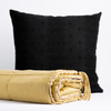 Taline Blanket | Taline bed end blanket in honeycomb folded with tassel on corner showing against an ines throw pillow in corvino - front view with white background.