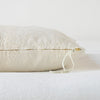 Ines Throw Pillow | Parchment | Close-up of brass zipper and charmeuse pull details on throw pillow - side view.