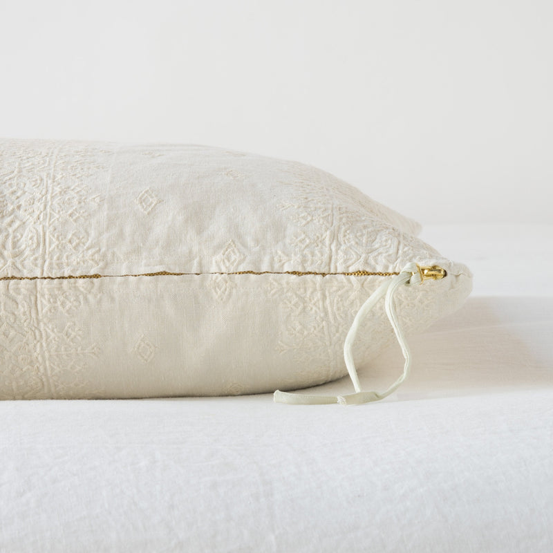 Ines Throw Pillow | Parchment | Close-up of brass zipper and charmeuse pull details on throw pillow - side view.