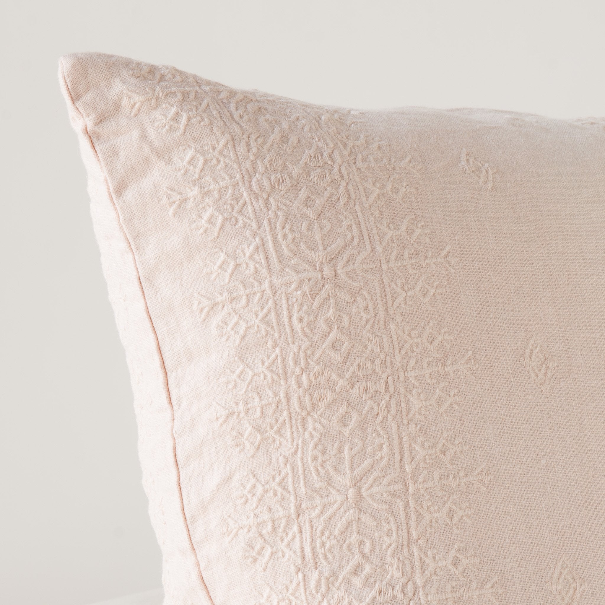 Ines Throw Pillow | Pearl | Close-up of pillow corner, showcasing the embroidery pattern detail.
