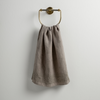 Ines Guest Towel | Fog | guest towel draped through a decorative brass towel ring against a white background.