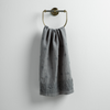 Ines Guest Towel | Moonlight | guest towel draped through a decorative brass towel ring against a white background.