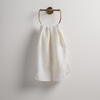 Ines Guest Towel | Winter White | guest towel draped through a decorative brass towel ring against a white background.