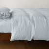 Ines Duvet Cover | Cloud | lightly rumpled duvet cover on a monochromatic bed against a white background - side view.