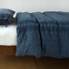 Ines Duvet Cover | Midnight | lightly rumpled duvet cover on a monochromatic bed against a white background - side view.