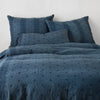 Ines Duvet Cover | Midnight | duvet cover and matching shams against a white wall - end of bed view.