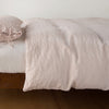 Ines Duvet Cover | Pearl | lightly rumpled duvet cover on a monochromatic bed against a white background - side view.