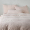 Ines Duvet Cover | Pearl | duvet cover and matching shams against a white wall - end of bed view.