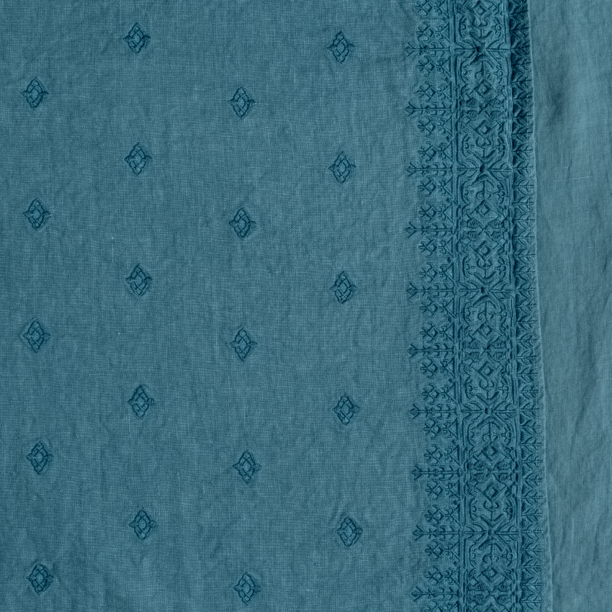 Ines Baby Blanket | Cenote | A close up of embroidered midweight linen fabric in cenote, a vibrant, ocean-inspired blue-green.