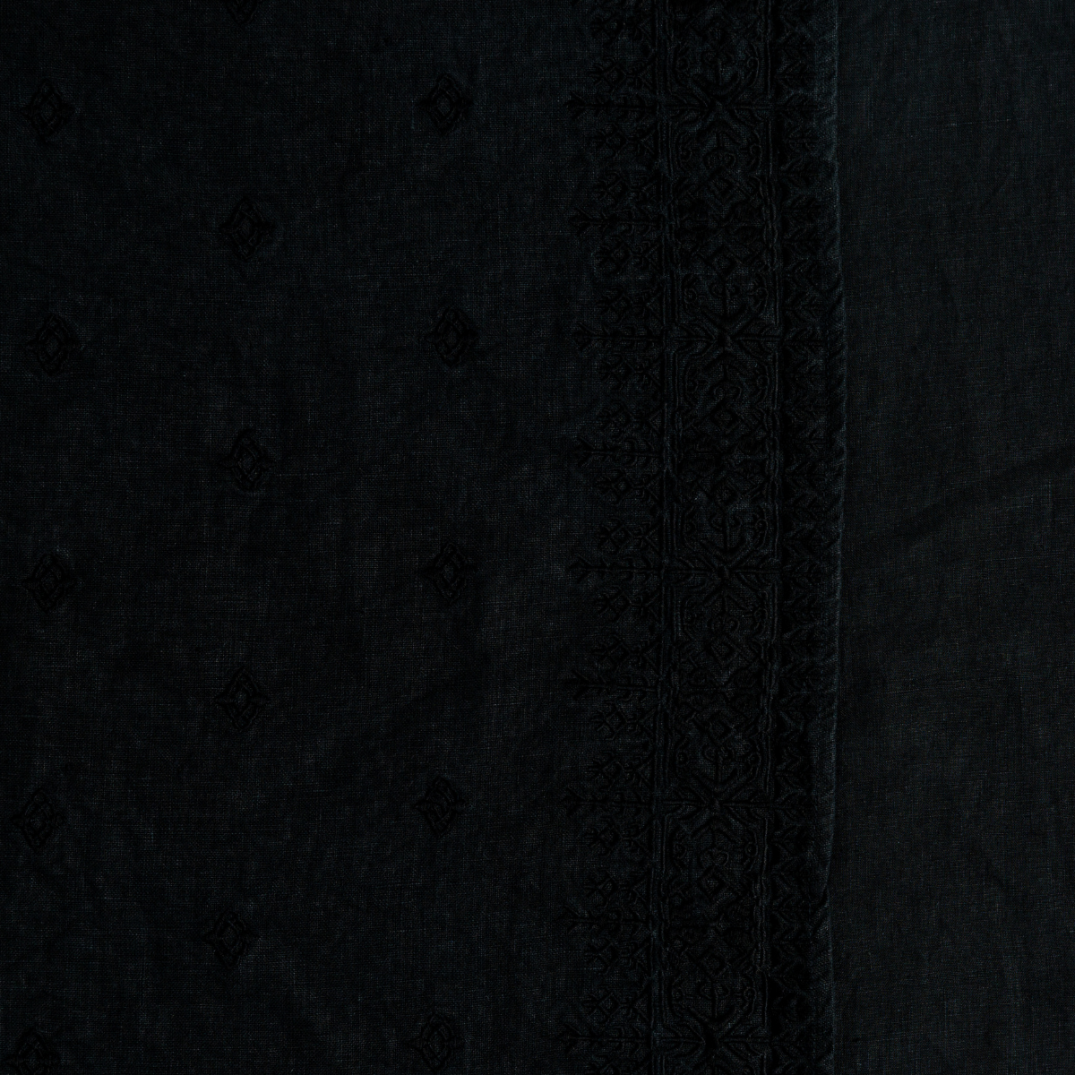 Ines Guest Towel | Corvino | A close up of embroidered midweight linen fabric in Corvino, a black tone.