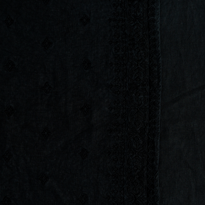 Ines Guest Towel | Corvino | A close up of embroidered midweight linen fabric in Corvino, a black tone.