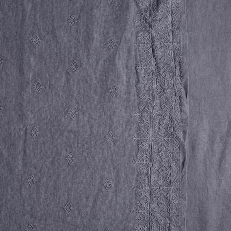 Ines Bedspread | French Lavender | a close up of embroidered midweight linen fabric in french lavender, a neutral violet tone.