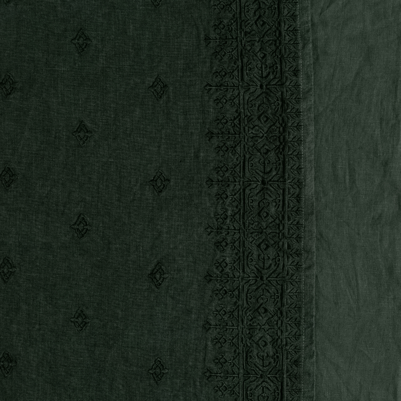 Ines Blanket | Juniper | A close up of embroidered midweight linen fabric in Juniper, a deep green tone.
