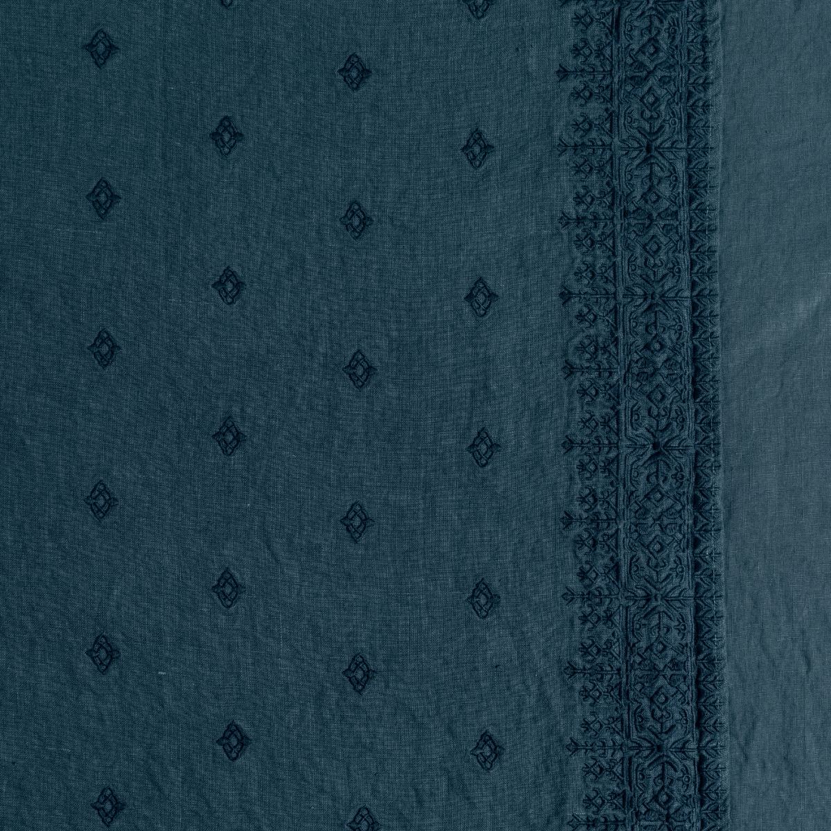 Ines Baby Blanket | Midnight | A close up of embroidered midweight linen fabric in midnight, a rich indigo tone.